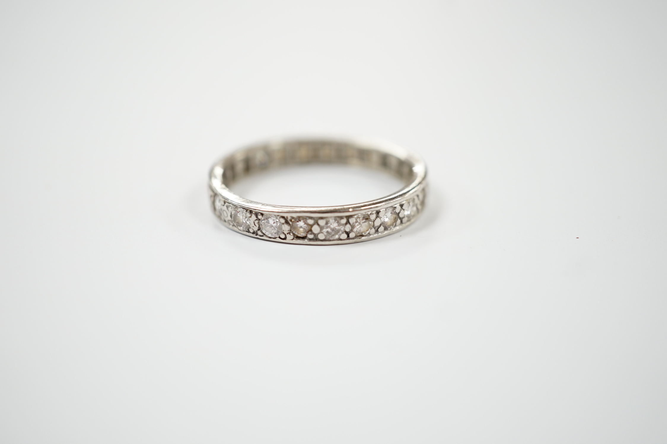 A white metal and diamond set full eternity ring, size U, gross weight 5 grams.